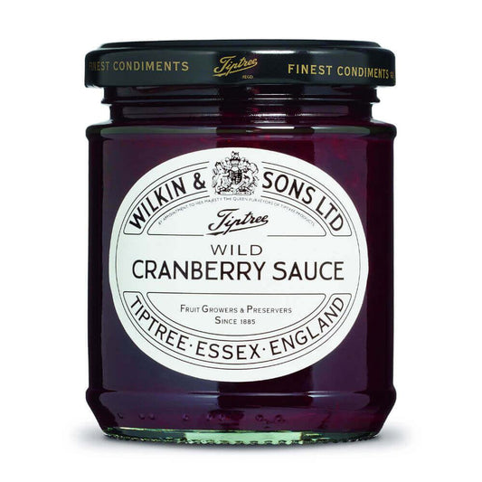 Ein Glas „Wilkin & Sons Tiptree Wild Cranberry Sauce“ (210 g), eine erlesene englische Fruchtsauce, mit einem weißen Etikett und schwarzer Schrift, auf dem der Produktname und die Herkunft angegeben sind: Tiptree, Essex, England. Die tiefrote Sauce im Glas spiegelt ihren intensiven Cranberry-Geschmack wider.