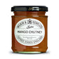 Ein 220-g-Glas mit „Wilkin & Sons Tiptree Chutney Mango“, mit einem weißen Etikett mit schwarzer Schrift und einem goldenen Deckel. Im Glas hat das Chutney eine goldorange Farbe.