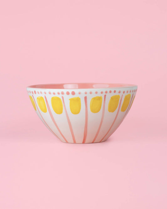 Die Alfar Tierra Cocida VALENTINA 1,5L handgefertigte Keramik-Servierschale in Rosa und Gelb besitzt eine weiße Basis mit pinken Streifen und gelben Ovalen, abgebildet vor einem rosa Hintergrund.