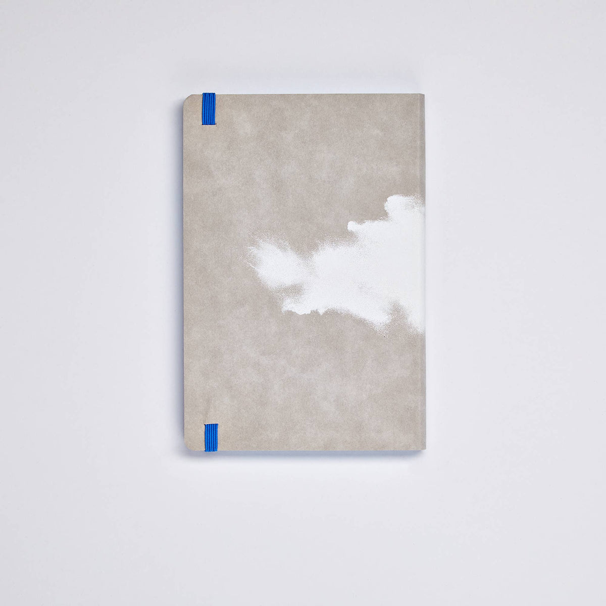 Ein geschlossenes nuuna „Cloud Blue“ Inspiration Book M mit 176 farbigen Seiten und einem markanten weißen, wolkenartigen Motiv auf dem grauen Einband, das durch blaue Eckbänder akzentuiert wird, liegt elegant auf einer weißen Fläche.