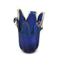 Die Murano Dream „Giusy“-Vase, eine mittelgroße Vase aus blauem Murano-Glas (H 24, Ø 19 cm) mit wellenförmigem Rand und bernsteinfarbenen Kanten, erinnert an eine blühende Blume – ein Meisterwerk der italienischen Glaskunst.