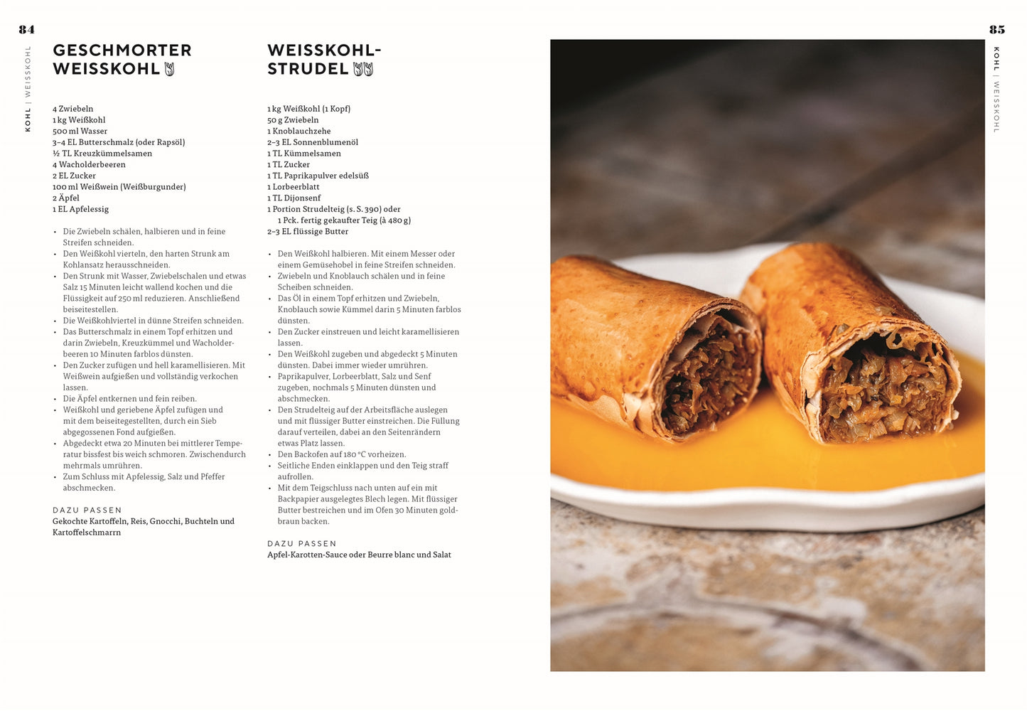 Eine Nahaufnahme von zwei mit Kohl gefüllten Strudeln, inspiriert durch das Buch Vegetarisch | Meisterwerk der vegetarischen Küche des DK Verlags, auf einem weißen Teller mit Orangensauce vor einer verschwommenen Steintischplatte.