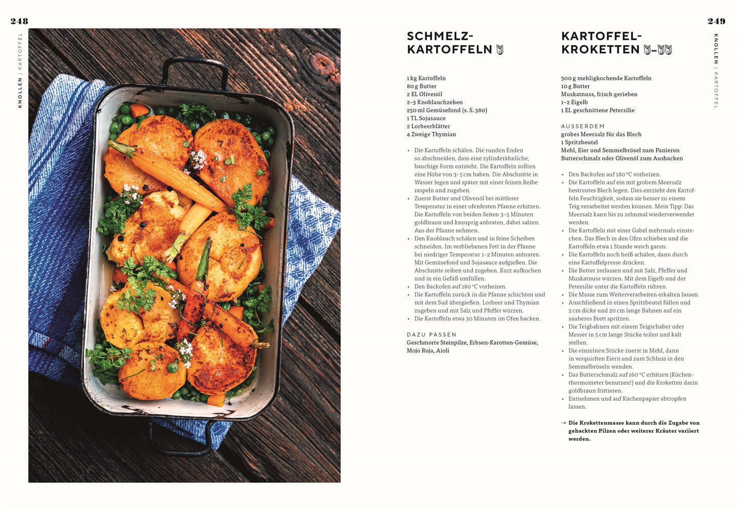Eine Auflaufform mit goldgelb gebratenen Kartoffelscheiben und Möhren aus "Vegetarisch | Meisterwerk der vegetarischen Küche" vom DK Verlag steht auf einem blauen Handtuch. In der Nähe liegen gekochte grüne Erbsen auf einer weißen Tischplatte verstreut.