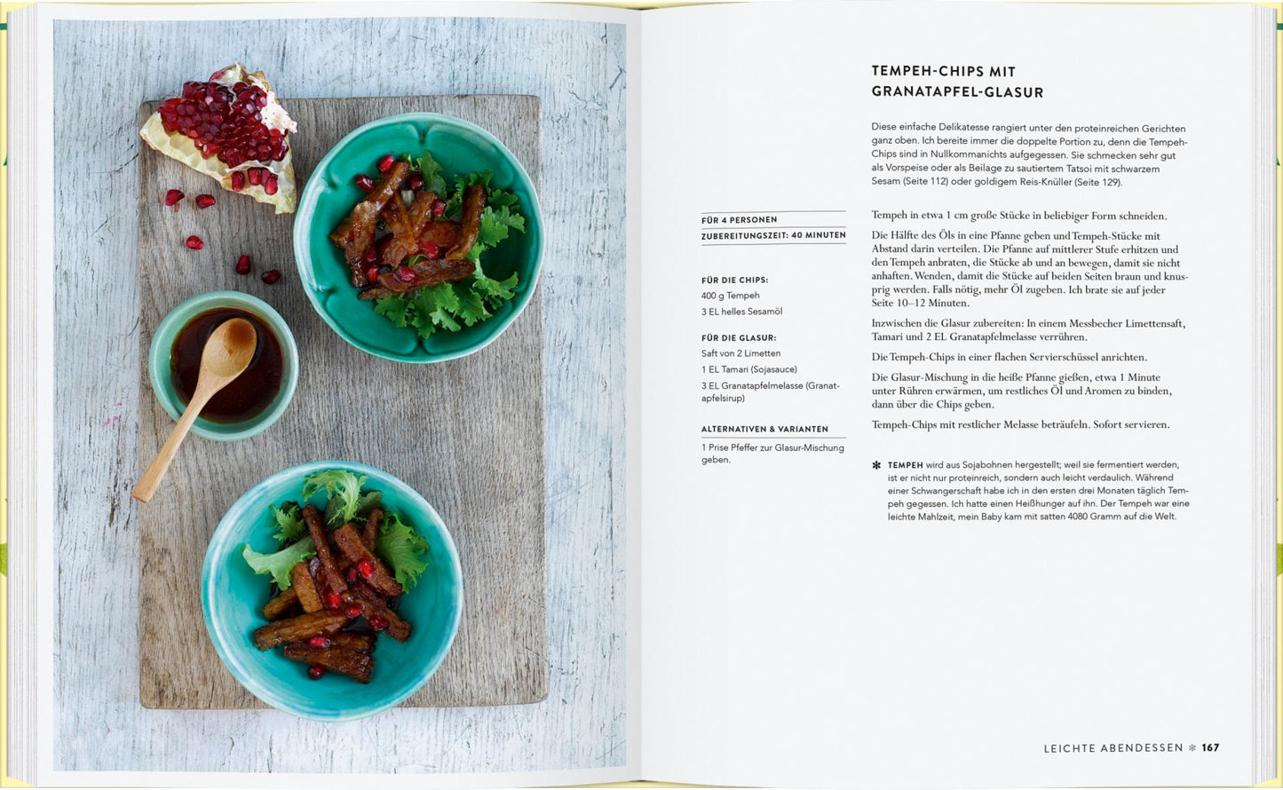 Ein aufgeschlagenes Kochbuch "Vergnügt Vegan | Rezepte und Tipps für die ganze Familie" aus dem Gerstenberg Verlag zeigt ein Rezept für Tempeh-Chips mit Granatapfelglasur, begleitet von zwei grünen Schalen mit dem Gericht, Sauce, Koriander und Granatapfelkernen auf einem weißen Tisch.