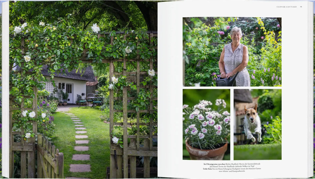 Aufgeschlagene Seiten aus dem Buch Die schönsten Cottage-Gärten Englands, auf denen ein englischer Cottage-Garten mit einem Holztor, einer Frau mit einer Gießkanne, einer Dianthus-Pflanze im Topf und einem springenden Jack-Russell-Terrier zu sehen ist.
