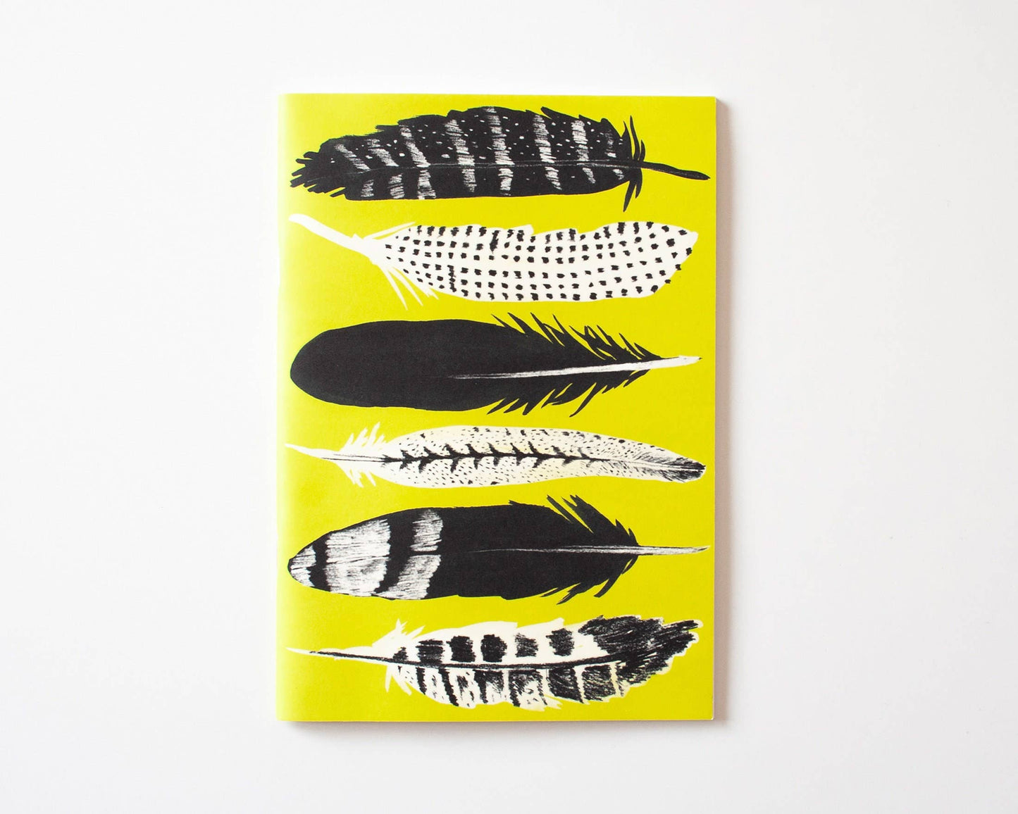 Das Papaya Paper Products Notizheft A5 in Gelb zeigt sechs schwarz-weiß illustrierte Federn auf weißem Munken Print Cream Papier. FSC-zertifiziert für nachhaltige Qualität.