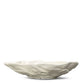 Die BYON | Design Schale Alima von Sagaform GmbH ist eine weiße Bone China Schale in Form einer Austernschale mit einer strukturierten, gewellten Oberfläche. Spülmaschinengeeignet für einfache Reinigung. Abgebildet vor einfarbig weißem Hintergrund.
