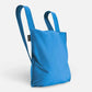 Die Notabag | „Original Blue“-Tasche von Notabag ist eine vielseitige blaue Tragetasche, ein Rucksack und eine Handtasche in einem – mit zwei breiten Tragegriffen, einem minimalistischen Design und einem kleinen schwarzen Etikett an der Seite – perfekt für stilvolle und nachhaltige Transportbedürfnisse.