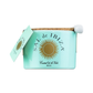 Ein hellblaues Sal de Ibiza | „Fleur de Sel“-Meersalz im 150-g-Keramikglas mit dem goldenen Sal de Ibiza-Sonnenlogo, einem Korkdeckel, einem angebrachten Etikett und einem kleinen weißen Keramiklöffel – ideal zum Servieren dieses erlesenen Meersalzes.