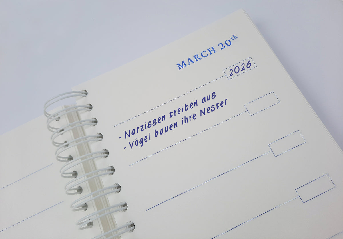 Ein aufgeschlagenes KGA-Gartentagebuch | „Five Years Diary“ (limitierte Auflage) der Königlichen Gartenakademie zeigt den 20. März 2026 mit handschriftlichen deutschen Notizen: „Narzissen treiben aus – Vögel bauen ihre Nester“, was so viel bedeutet wie „Narzissen sprießen – Vögel bauen ihre Nester“. Dieses bezaubernde Gartentagebuch ist Ihre persönliche Gartenchronik, um die jahreszeitlichen Veränderungen der Natur festzuhalten.