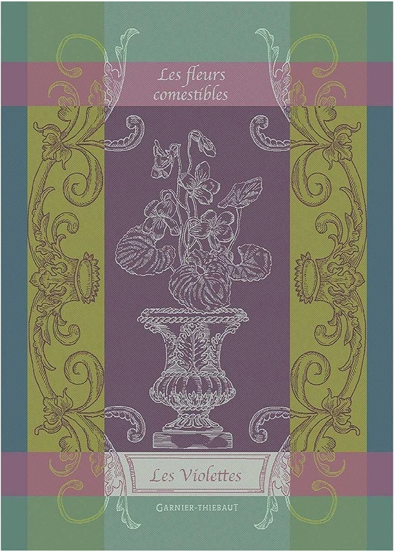 Ein dekorativer Einband mit verschnörkelten Goldmotiven und Veilchen in einer Vase trägt den Titel Les fleurs comestibles" und Les Violettes" in Anlehnung an das Geschirrtuch Les Violettes" von Garnier Thiebaut, darunter der Name des Herausgebers.