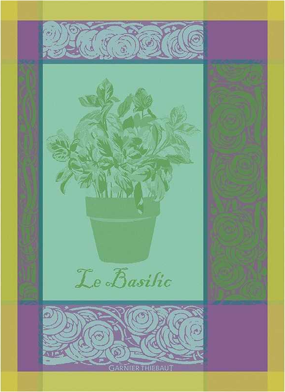 Das Garnier Thiebaut Geschirrtuch 'Le Basilic' zeigt eine dekorative Basilikumpflanzen-Illustration mit der Aufschrift "Le Basilic" in französischer Sprache darunter, inspiriert vom ikonischen Küchentuch Baumwolle, sowie eine grün, gelb und violett gemusterte Bordüre.
