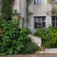 Genießen Sie den Afternoon Tea der Königlichen Gartenakademie am Di. 20.10.2026, 14:30-16:00 Uhr, inspiriert von den Gärten der Normandie - erleben Sie eine bezaubernde Umgebung mit üppigem Grün, schwarz gerahmten Fenstern und Steinarchitektur.