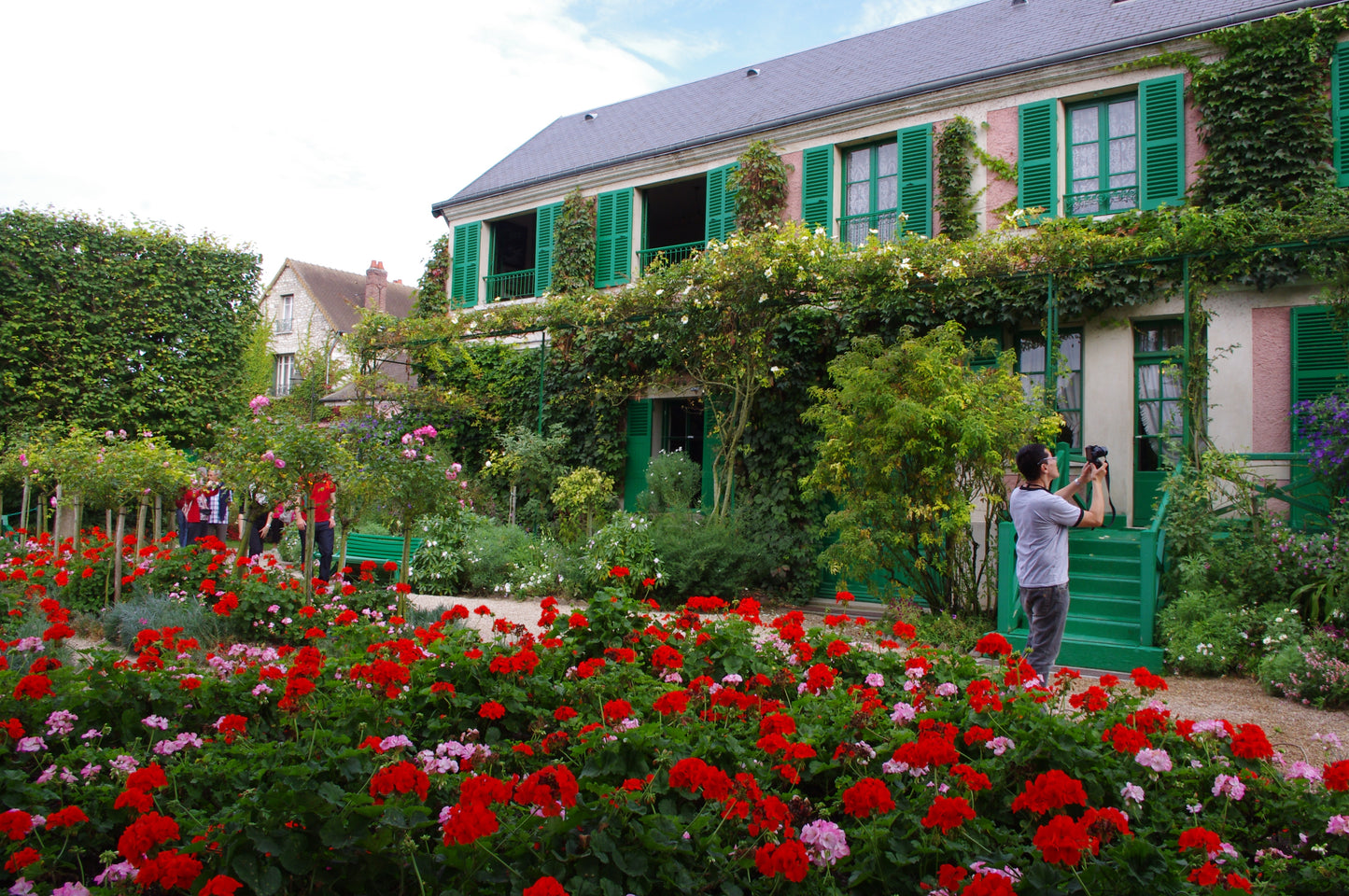 Genießen Sie die Gärten der Normandie in der Königlichen Gartenakademie: Kommen Sie zum Afternoon Tea und einem Vortrag am Di, 20.10.2026, 14:30-16:00, umgeben von leuchtend roten Blumen und grünem Laub - ein inspirierendes Gartenerlebnis!.