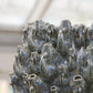 Wir stellen vor: Des Pots | Vase „Fisch“, klein, in Blau aus Steingut (H 18 cm, Ø 23 cm) von Des Pots – ein handgeformtes Designstück aus Steingut, glasiert in Blautönen, das mit mehreren aneinandergereihten Fischköpfen und geöffneten Mündern beeindruckt. Diese außergewöhnliche Designer-Vase verbindet kunstvolle Handwerkskunst mit markanter optischer Ausstrahlung und wird stilvoll auf einem Holzsockel im Innenbereich präsentiert.