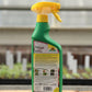 Eine grüne Neudorff BioKraft Grundstoff Brennnessel 500 ml Sprühflasche mit gelbem Abzug steht auf Holz, Rückenetikett sichtbar, inmitten unscharfer Gewächshauspflanzen - ideal für natürlichen Pflanzenschutz gegen Blattläuse.