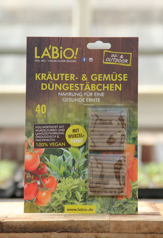 Eine Packung La'Bio Düngestäbchen 40 Stk. von La'Bio, gekennzeichnet als 100% vegan und reich an pflanzlichen Nährstoffen, für den Innen- & Außenbereich, abgebildet auf Holz mit unscharfem Hintergrund.