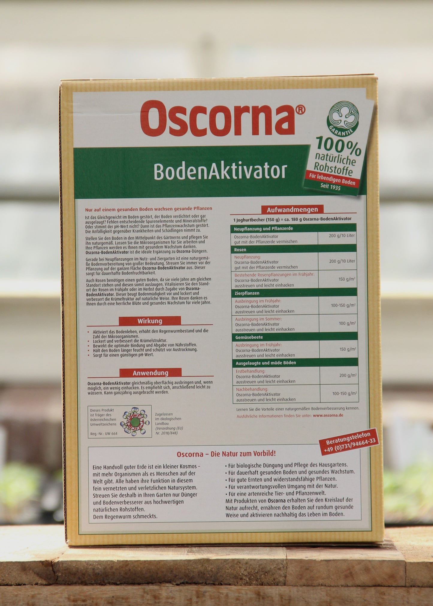 Auf einer Holzfläche ist eine 3 kg-Packung Oscorna | Boden Aktivator abgebildet, ein Bodenaktivator, der das Bodenleben und das gesunde Pflanzenwachstum fördert. Die deutsche Verpackung zeigt Anwendungshinweise, Vorteile und Anwendungstabellen.