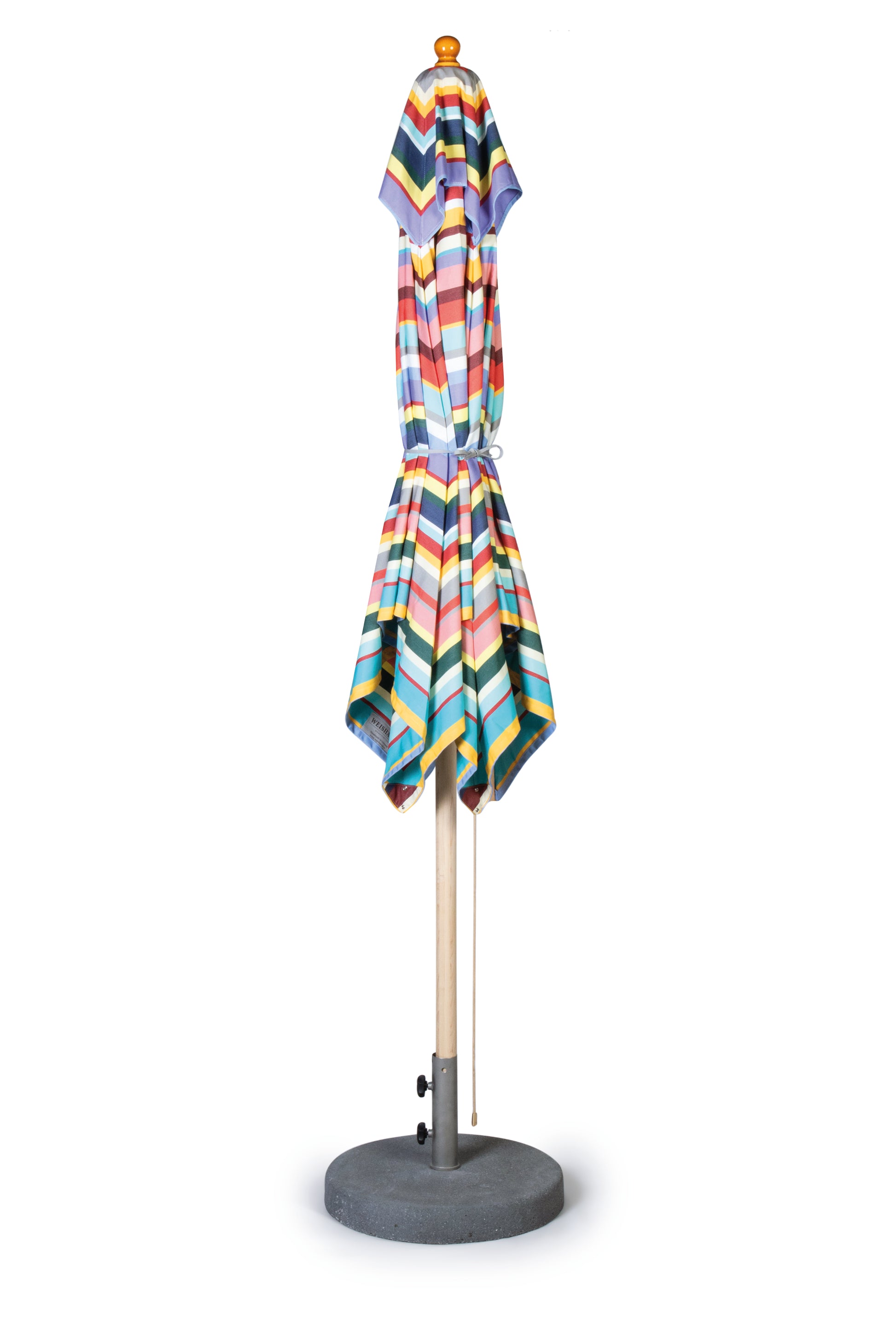 Der Weishäupl Acryltuch-Sonnenschirm 'Klassiker Multicolor' mit Flaschenzug & Knick (Ø 250 cm) steht geschlossen in einem runden grauen Sockel vor weißem Hintergrund - ein lebendiges, unverzichtbares Outdoor-Accessoire.