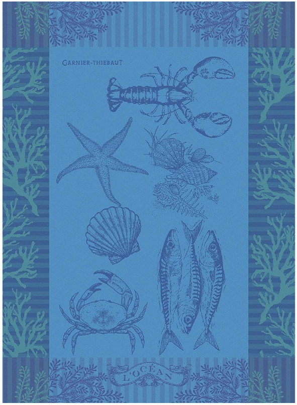 Das Garnier Thiebaut Geschirrtuch 'L'Ocean Bleu' zeigt Meerestiere und Algen mit dem Schriftzug "Garnier-Thiebaut" und "L'Océan" und verleiht Ihrer Küche einen ozeanisch inspirierten Charme im typischen Garnier Thiebaut Stil.