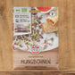 Eine Packung Sperli's Bio Keimsprossen Saatgut 'Mungbohnen' wird auf Holz präsentiert, mit der Marke Sperli's, Bildern von Mungbohnensprossen, einem Bio-Etikett, Servierideen und einem deutschen Text über diese Bio-Keimsprossen.