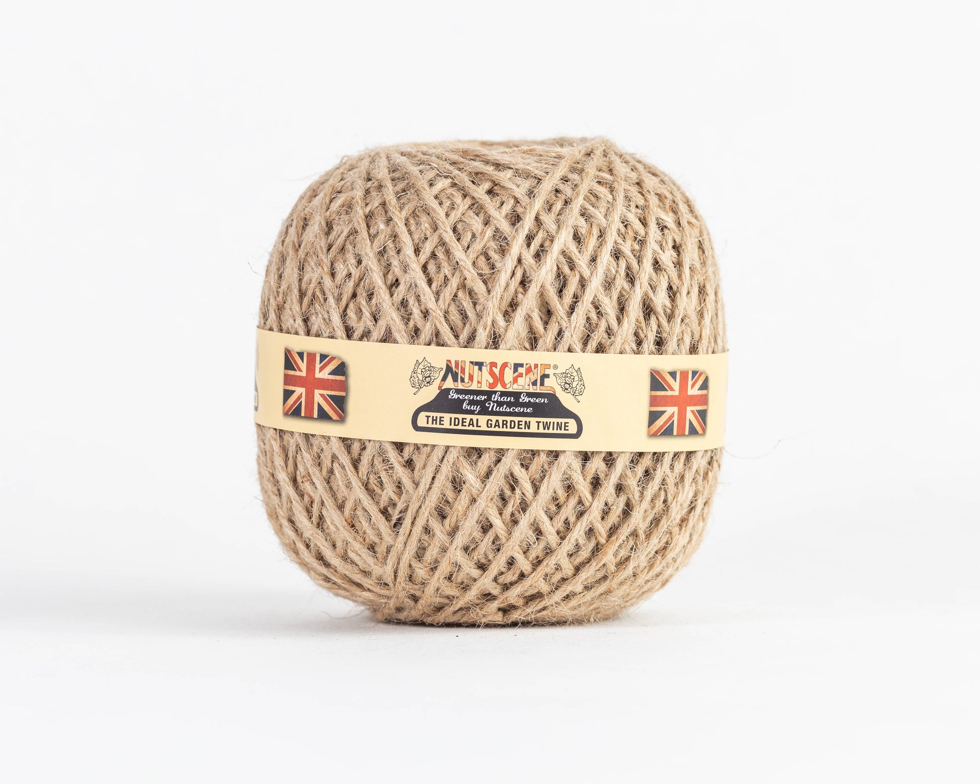 Ein fest aufgerollter Knäuel Nutscene | Heritage Jutegarn in der Farbe „Natur“ (130 m) von Nutscene Twines Ltd ist abgebildet, versehen mit einem beigen Etikett, auf dem zwei britische Flaggen und der Schriftzug „THE IDEAL GARDEN TWINE“ zu sehen sind. Vor einem weißen Hintergrund präsentiert sich diese naturfarbene Gartenschnur, die sich perfekt für alle Ihre Jutegarn-Anwendungen eignet.