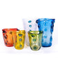Fünf farbenfrohe Glasvasen - rot, gelb, grün, weiß und die Des Pots Skulpturale Vase blau (H 22 cm Ø 20 cm) mit gewellten Rändern und erhabenen Punkten - sind gemeinsam auf weißem Grund angeordnet. Eine auffällige Ergänzung für jede Des Pots-Sammlung.
