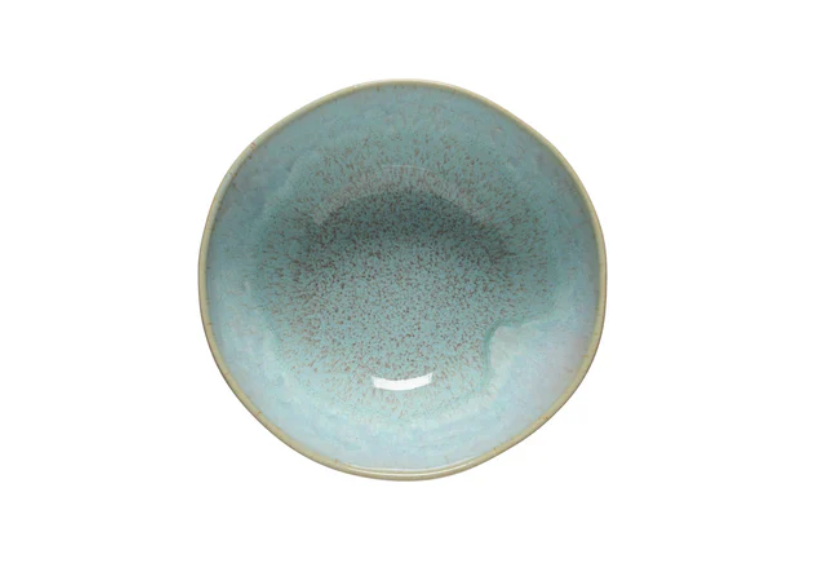 Eine runde, flache Costa Nova 'Eivissa sea blue' Müslischale (Ø 16 cm, H 7,7 cm) mit leicht unregelmäßiger Form und glänzender Oberfläche, handgefertigt aus Steingut in Portugal, von oben gesehen auf weißem Grund.