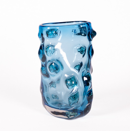 Die Vase Des Pots skulpturale aus blauem, mundgeblasenem Glas mit unebener Oberfläche und unebenem Rand (H 32 Ø 21 x 23 cm) wird vor einem schlichten weißen Hintergrund gezeigt.