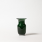 Die Des Pots | Grün Vase aus Glas in Kelchform (H 18 cm, Ø 11 cm) von Des Pots hat einen glänzend dunkelgrünen, breit ausgestellten Rand und einen abgerundeten Körper. Sie steht auf einem schlichten weißen Hintergrund, der einen weichen Schatten nach rechts wirft.