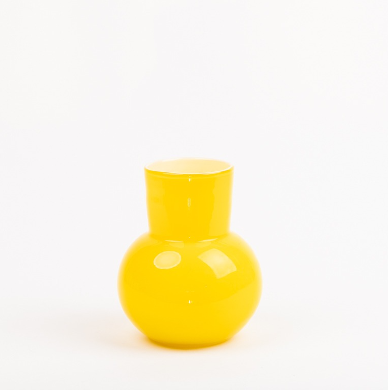 Die Des Pots | Gelbe Vase aus Glas (H 21 Ø 18 cm) von Des Pots präsentiert sich glänzend und rund mit schmalem Hals und breitem Fuß als stilvolles Wohnaccessoire vor schlichtem, weißem Hintergrund.