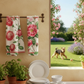Ein Küchenfenster mit Napkings Premium Leinen Geschirrtuch 'Cecile', getopften Kräutern und gestapeltem Geschirr bietet einen Blick auf einen Garten mit rosa Rosen, Lavendel und einem verspielten Hund im Gras.