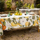 Ein rustikaler Gartentisch für vier Personen ist mit der Napking Premium Leinen Tischdecke 'Amalfi' (110 x 110 cm) eingedeckt; dekoriert mit Zitronen und Grünzeug unterstreicht sie Napkings italienische Handwerkskunst.