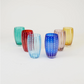 Sechs farbenfrohe „Zafferano Perle Glas“-Becher, meisterhaft aus mundgeblasenem Glas gefertigt und ein Paradebeispiel für exquisite italienische Glasmacherkunst, sind mit vertikalen weißen Punktlinien verziert und kunstvoll versetzt auf einem schlichten weißen Hintergrund angeordnet. Das von Zafferano hergestellte Set umfasst Gläser in den Farben Grün, Rot, Hellblau, Dunkelblau (Blau 32 cl), Rosa und Gelb.
