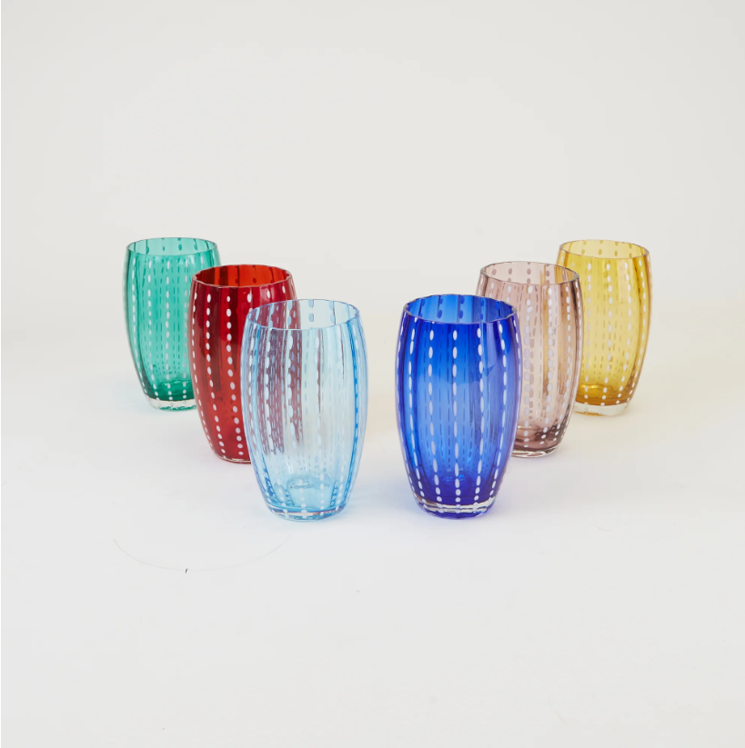 Sechs farbenfrohe „Zafferano Perle Glas Rot“-Becher, jeweils mit vertikalen gepunkteten Linien verziert und nach traditioneller italienischer Glasbläserkunst gefertigt, sind in zwei Reihen auf weißem Hintergrund angeordnet. Jeder mundgeblasene Glasbecher von Zafferano besticht durch eine einzigartige Farbe – grün, rot, blau, violett, hellblau und gelb – und sorgt so für ein lebhaftes Gesamtbild.