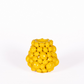 Eine kleine, glänzend gelbe Vase „Des Pots | Vase mit Zitronen in Gelb“ (H 16, Ø 16 cm) von Des Pots mit ihren an Zitronen erinnernden, gruppierten, abgerundeten Formen verleiht jedem Ambiente vor einem schlichten weißen Hintergrund einen Hauch von mediterraner Eleganz.