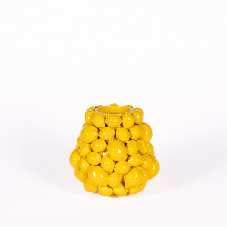 Eine kleine, glänzend gelbe Vase „Des Pots | Vase mit Zitronen in Gelb“ (H 16, Ø 16 cm) von Des Pots mit ihren an Zitronen erinnernden, gruppierten, abgerundeten Formen verleiht jedem Ambiente vor einem schlichten weißen Hintergrund einen Hauch von mediterraner Eleganz.