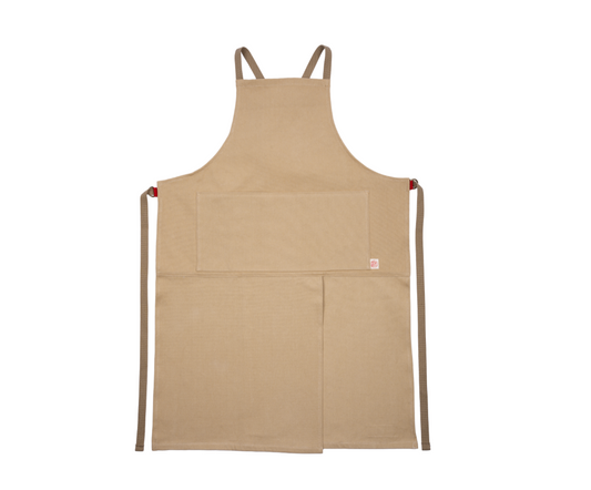 Eine beigefarbene Niwaki | Schürze „Split Apron“ (94 x 63 cm) von Niwaki mit zwei Vordertaschen und braunen Bindebändern liegt flach auf einem weißen Hintergrund. Diese praktische Schürze im „Split Apron“-Stil eignet sich ideal für Gartenarbeiten oder Bastelarbeiten.