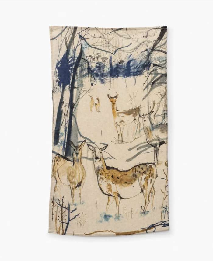 Wir präsentieren das Sam Wilson Küchentuch „The Herd“ – ein in England hergestelltes Handtuch aus 100 % Baumwolle mit einem kunstvollen Motiv, das Rehe in einem verschneiten Wald mit blau und braun skizzierten Bäumen zeigt und den Charme des britischen Landhausstils perfekt einfängt.