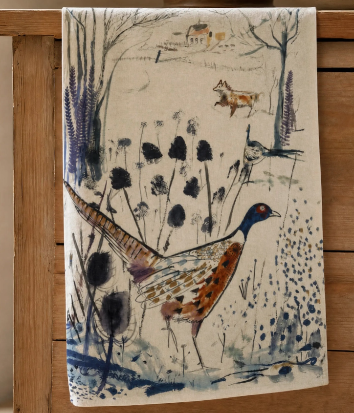 Das Sam Wilson-Küchentuch „Pheasant & Fox“ wird in England aus 100 % Baumwolle hergestellt. Es zeigt ein illustriertes Motiv mit einem Fasan und einem Fuchs in einer idyllischen Landschaftsszene – umgeben von Pflanzen, einem Vogel, kahlen Bäumen und einem Haus in der Ferne –, kunstvoll auf hochwertiger Baumwolle dargestellt.
