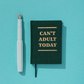 Ein weißer Füllfederhalter und ein Ohh Deer „Can’t Adult Today“-Mini-Notizbuch im Format A7 in Dunkelgrün mit goldener Beschriftung, beide vor blauem Hintergrund.