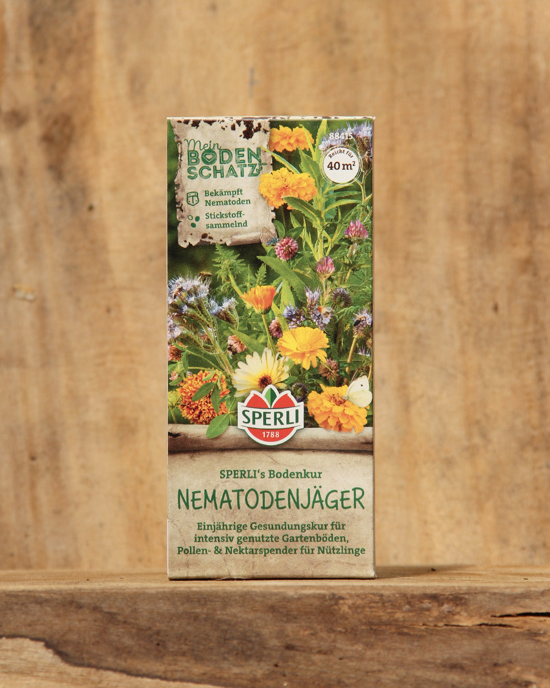 Eine 100 g Dose Sperli's Nematodenjäger Saatgut zeigt leuchtende Blüten und üppiges grünes Blattwerk, auf Deutsch bezeichnet als Gründüngermischung zur Bodenverbesserung und effektiven Nematodenbekämpfung. Marke: Sperli's.