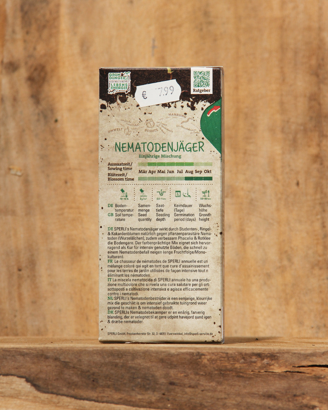 Eine rechteckige Schachtel mit Nematodenjäger Bodenkur Saatgut 100 g von Sperli steht aufrecht auf rustikalem Holz. Das Etikett auf der Vorderseite enthält Angaben zum deutschen Anbau, die Marke Sperli's und einen Preisaufkleber über 7,99 €.