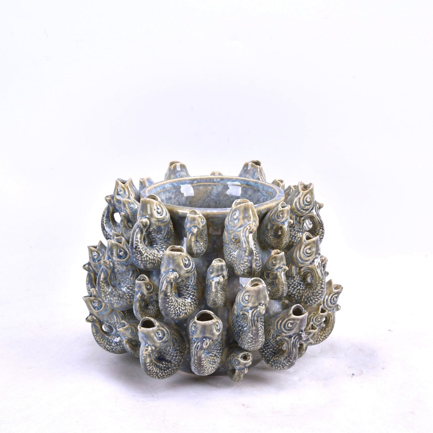 Die Des Pots Vase 'Fisch' klein (blau, Steingut, H 18 cm, Ø 23 cm) beeindruckt mit glänzender Glasur und skulpturierten Fischfiguren. Das wasserdichte Designobjekt steht vor weißem Hintergrund.