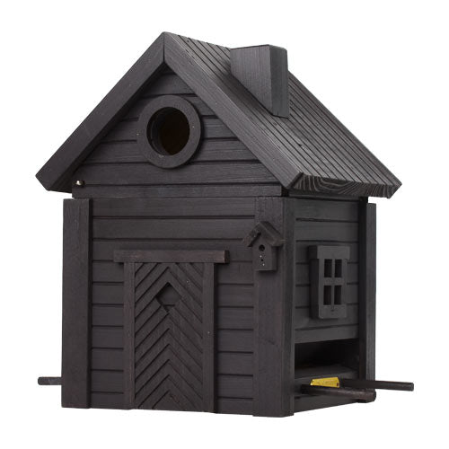 Das Wildlife Garden Nistkasten & Futterhaus in Carbon Black kombiniert eine stilvolle Hausform mit einem runden Eingang, einem schrägen Dach, unechten Fenstern und Türen sowie einer kleinen Sitzstange an der Vorderseite.