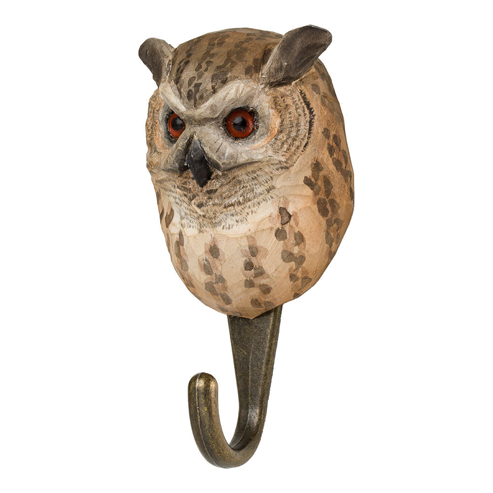 Der Wildlife Garden 'Uhu' Handgeschnitzter Wandhaken aus Lindenholz zeigt einen Eulenkopf mit feinen Federn, roten Augen und spitzen Ohren; der gebogene Metallhaken bringt natürlichen Charme in Ihr Zuhause.