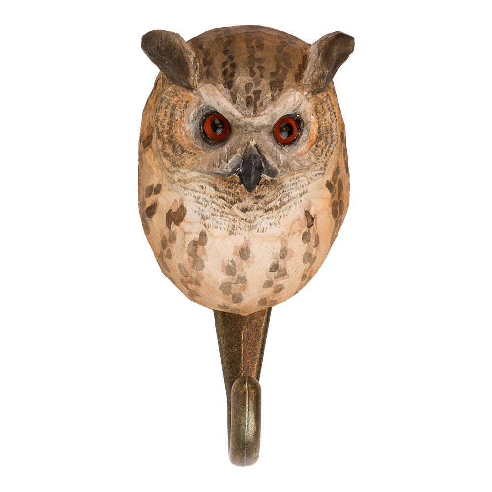 Der 'Uhu' Wandhaken von Wildlife Garden ist aus Lindenholz handgeschnitzt und zeigt einen Eulen-Kopf mit braun-beigen Federn, roten Augen und spitzen Ohren. Der Metallhaken sitzt am Halsansatz der detailreichen Figur.