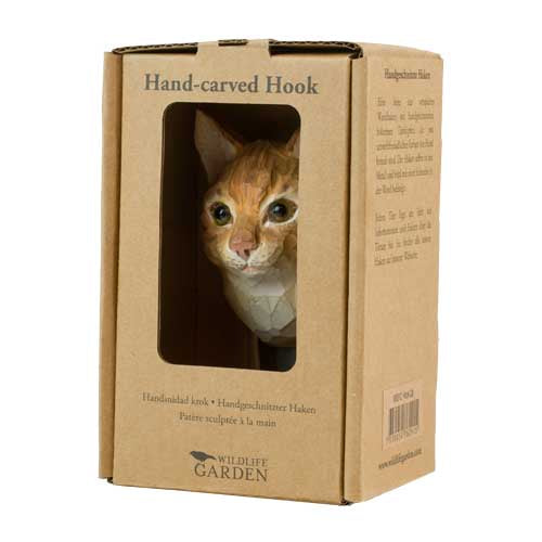 In einer Pappschachtel befindet sich der Wildlife Garden Handgeschnitzter Wandhaken aus Holz 'Hauskatze', ein Katzenkopf und Hals Wandhaken mit orangen und weißen Felldetails - ideal als Katzen Deko oder Geschenk für Naturliebhaber. Marke: Wildlife Garden.