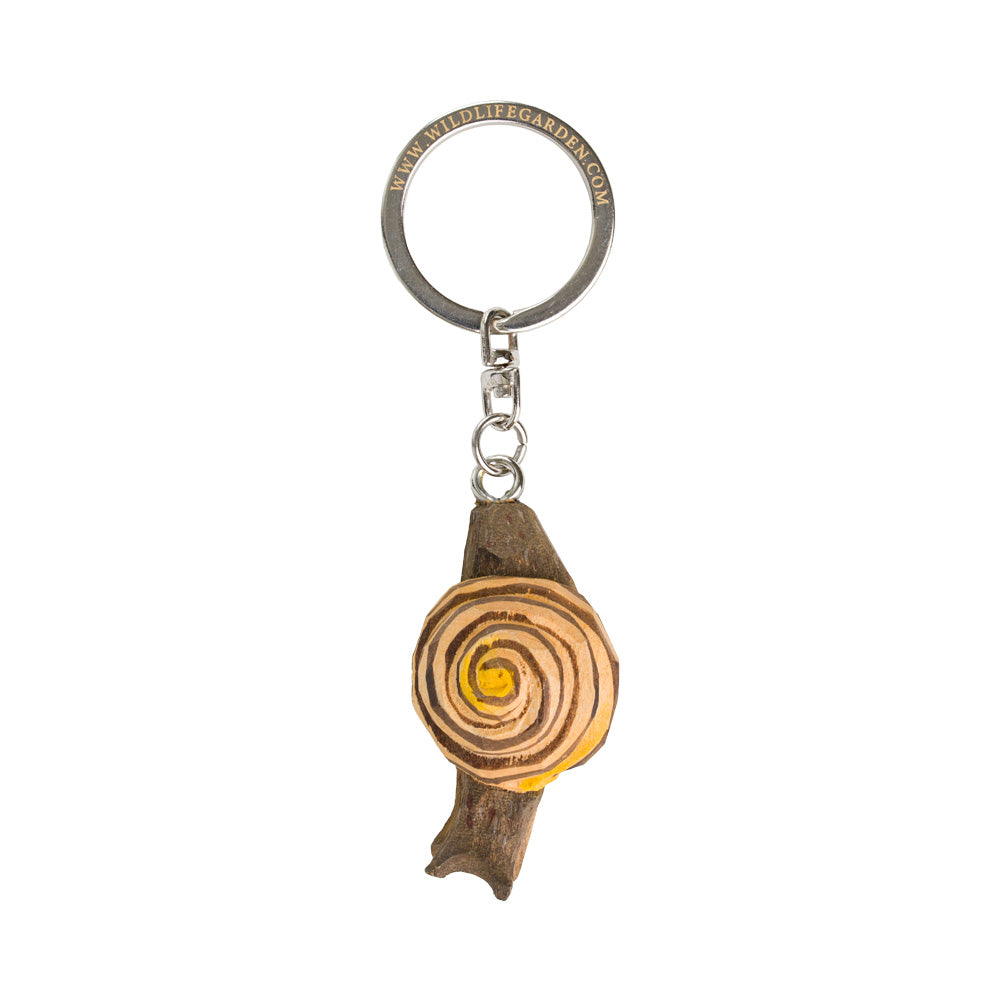 The Wildlife Garden Schlüsselanhänger 'Schnecke' ist ein handgefertigter Holzanhänger mit Spiraldesign, inspiriert von einem Baumquerschnitt, und kommt mit Metallring und Kette.