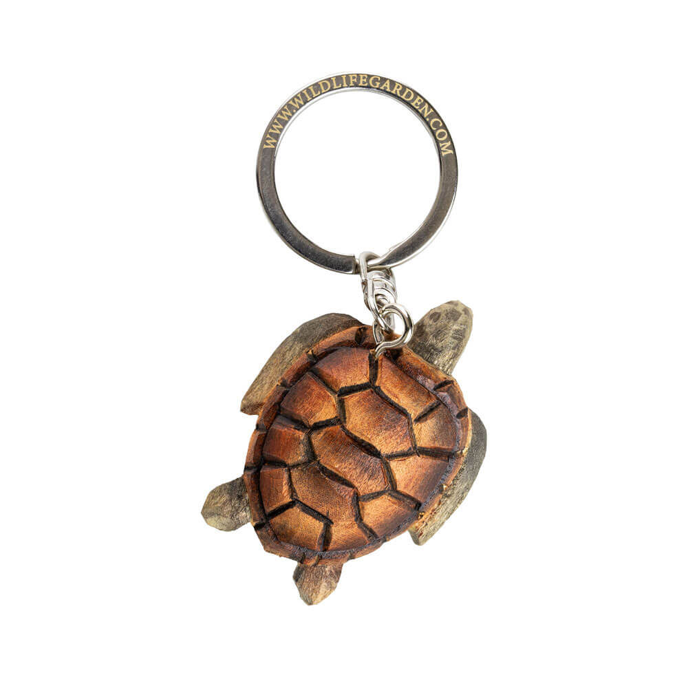 Der Wildlife Garden Handgefertigter Schlüsselanhänger aus Holz - Schildkröte zeigt eine detaillierte, braune Meeresschildkröte mit strukturiertem Panzer und realistischer Form, befestigt an einem Metallring.